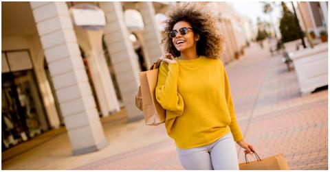 A Black woman shopping and holding shopping bags