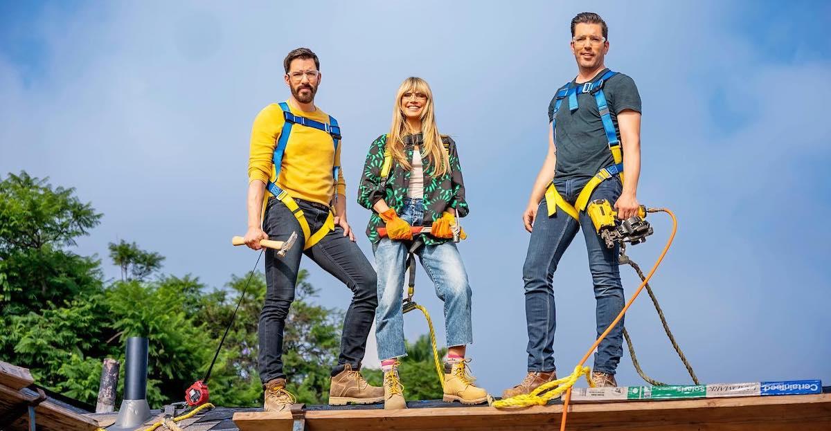 Jonathan Scott, Heidi Klum, and Drew Scott posing for 'Celebrity IOU' on a roof