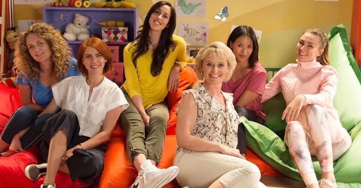 The cast of 'Workin' Moms' sitting on colorful chairs.