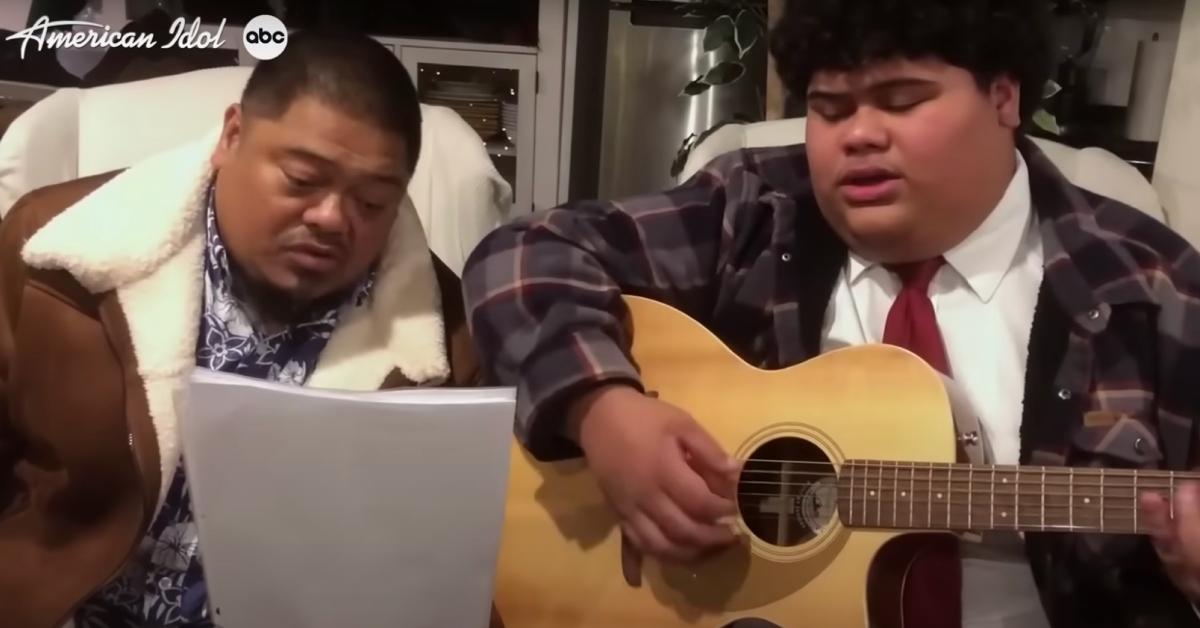 Iam Tongi plays a guitar next to his dad Rodney.