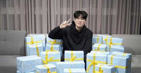 Zeus offering a peace sign surrounded by wrapped pressents.