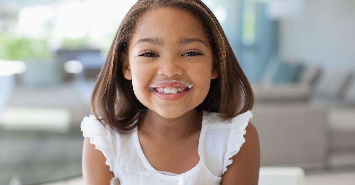 A young girl drinking milk