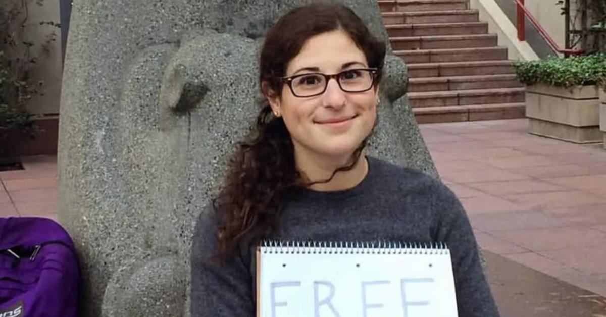 Annie Altman holds up a sign that reads Free Hugs