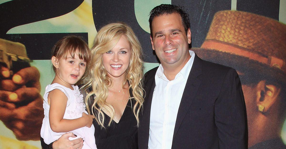 Ambyr Childers stands at center holding her daughter to the left as Randall Emmett stands to her right