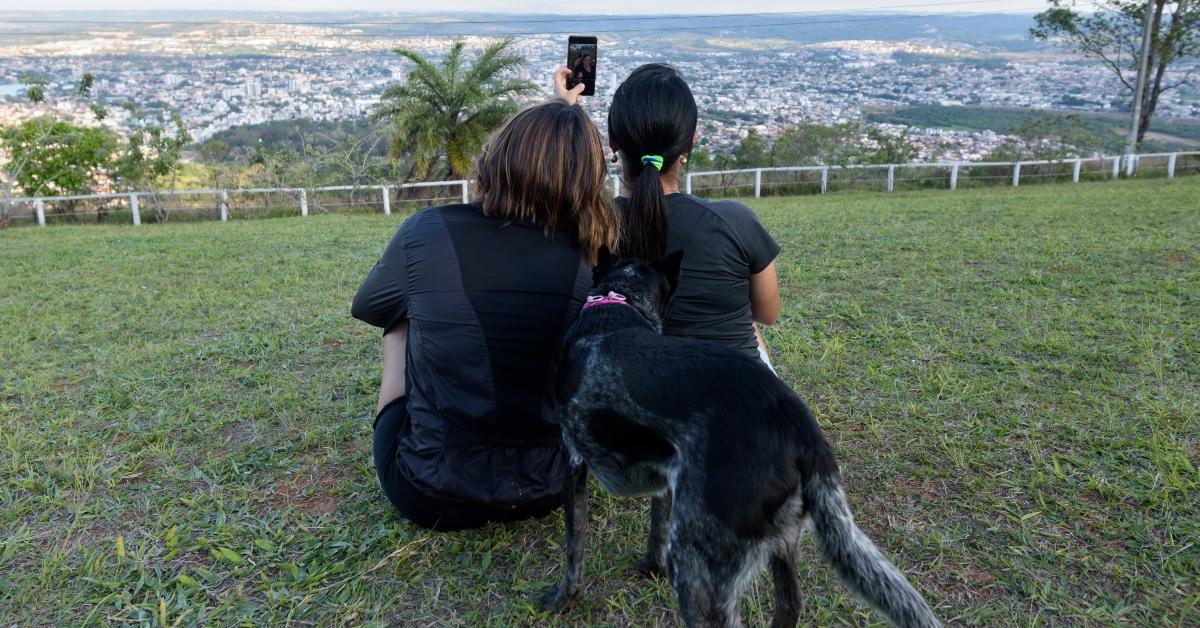 Mother and daughter sitting on the lawn taking selfie with their pets - stock photo - Mother and daughter sitting on the lawn taking selfie with their pets