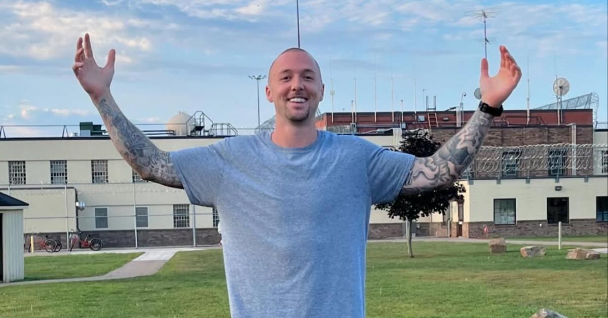 Brett Booker stands in front of a prison.