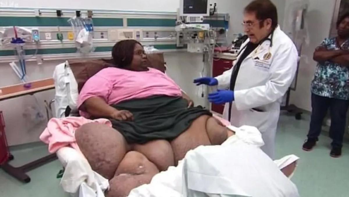 Liz Evans lying in a medical bed speaking to Dr. Now on 'My 600-lb Life'.