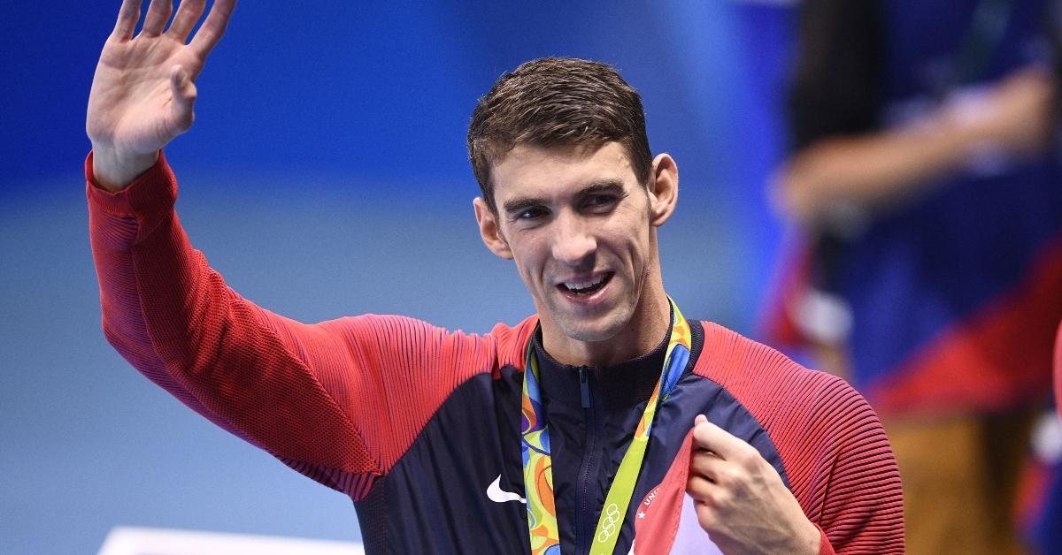 USA's gold medallist Michael Phelps waves after the podium ceremony of the Men's swimming 4 x 100m Medley Relay Final at the Rio 2016 Olympic Games at the Olympic Aquatics Stadium in Rio de Janeiro on August 13, 2016. (Photo by Martin BUREAU / AFP) (Photo by MARTIN BUREAU/AFP via Getty Images)