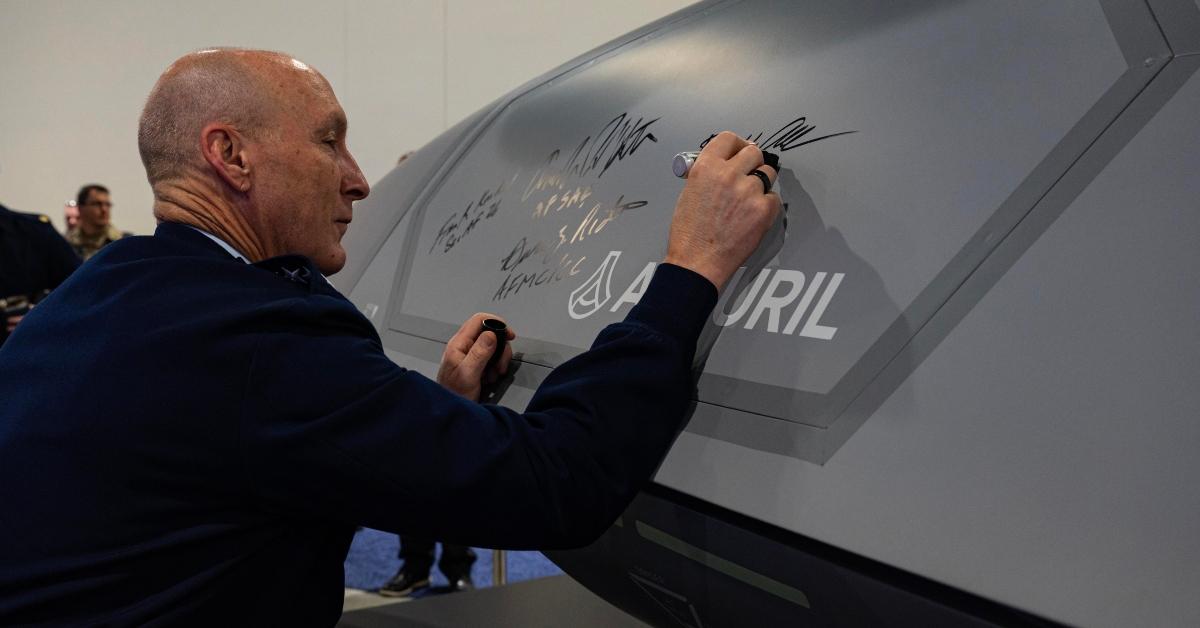David Allvin signs an aircraft.