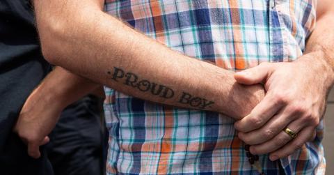 A man with a ''Proud Boys'' tattoo observes a protest calling for the statue of St. Louis to be removed from Forest Park