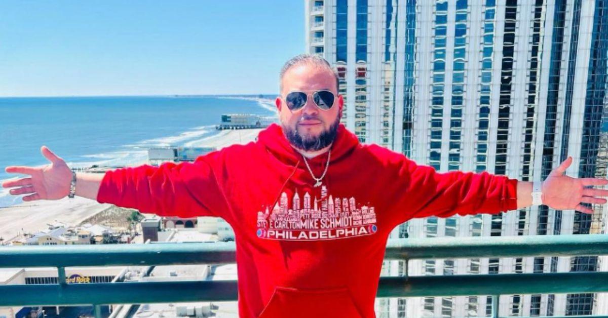 Jon Gosselin poses with his arms outspread in front of an Atlantic City, NJ beachfront