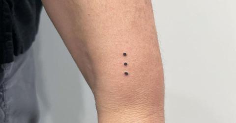 A vertical party dot tattoo on someone's arm