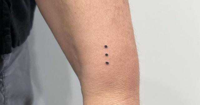 A vertical party dot tattoo on someone's arm