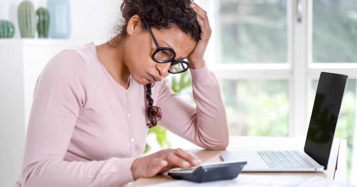 A woman stresses while looking at her bills.