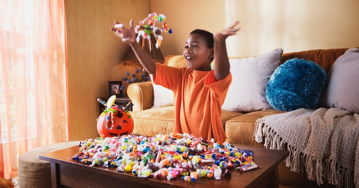 A child throwing up Halloween candy in the air. 