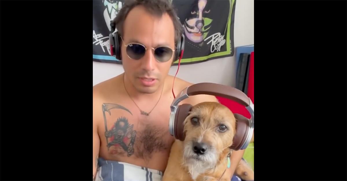 Ben Katzman with his shirt off with headphones on himself and his dog. 