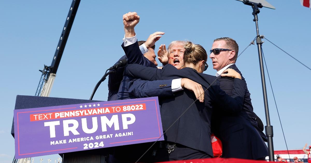  Republican presidential candidate former President Donald Trump is rushed offstage during a rally on July 13, 2024 in Butler, Pennsylvania. Butler County district attorney Richard Goldinger said the shooter is dead after injuring former U.S. President Donald Trump, killing one audience member and injuring another in the shooting. (Photo by Anna Moneymaker/Getty Images)
