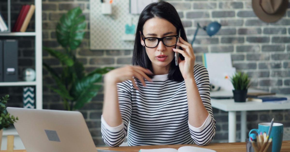 Woman on a cell phone at her desk
