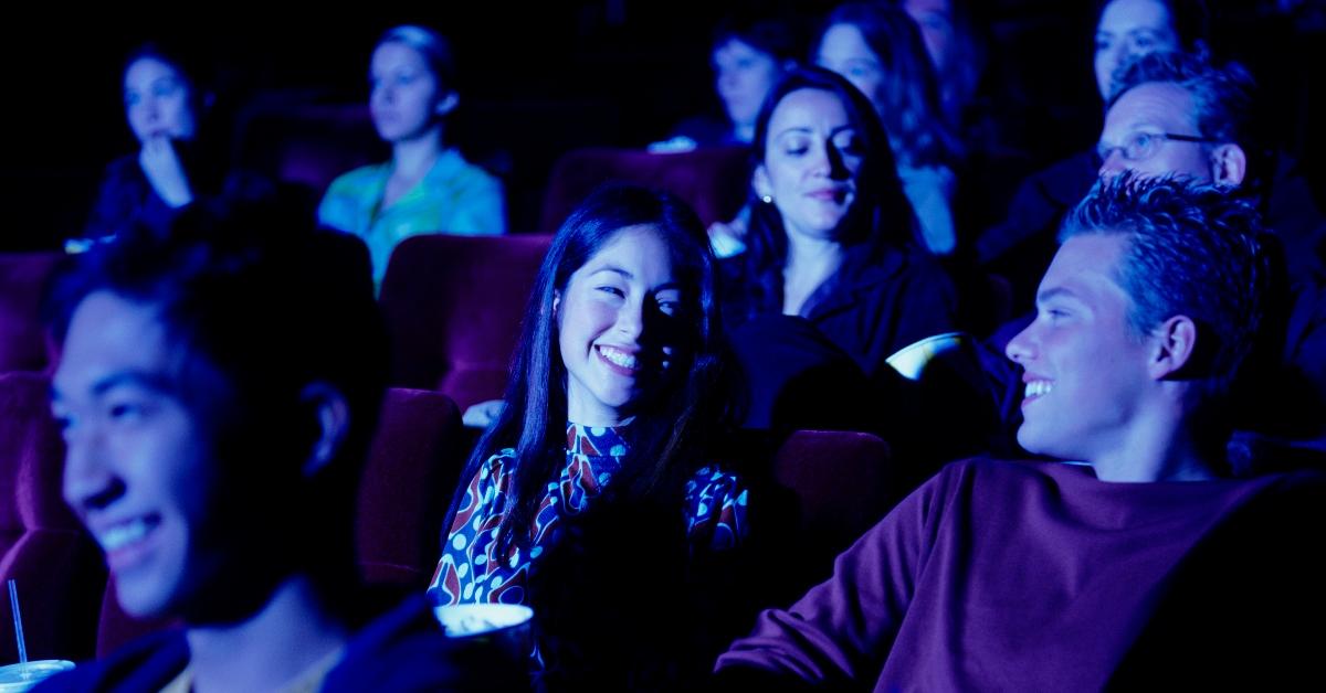 guy smiles at girl as they sit in audience and enjoy a show