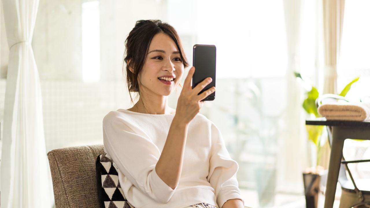 A woman holding her phone and doing a video chat