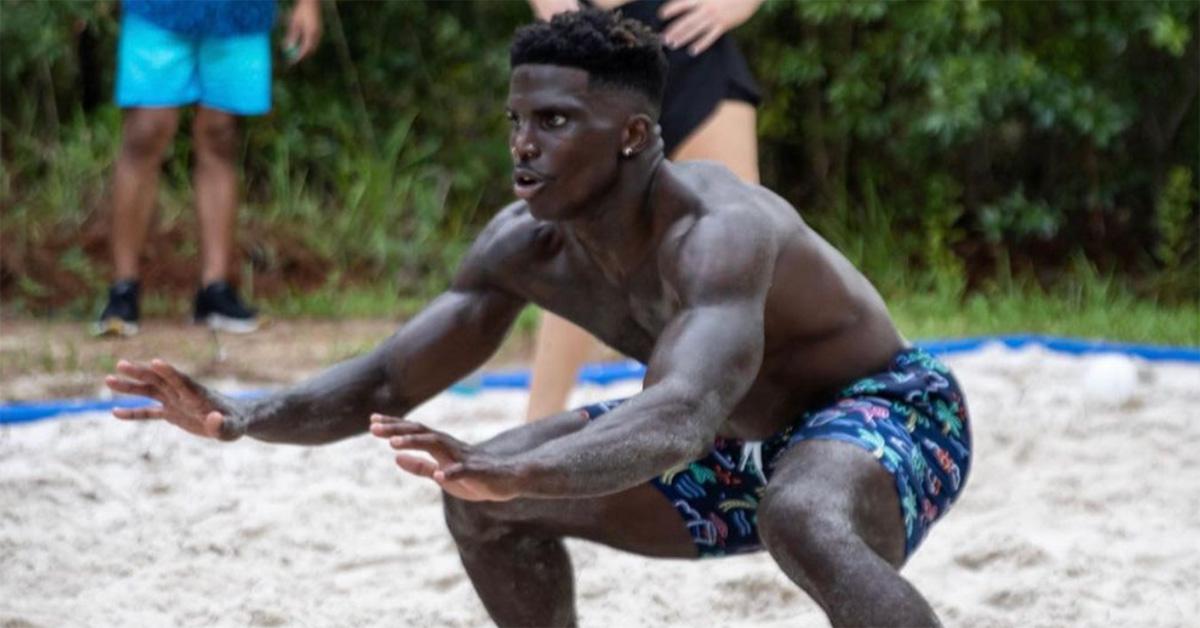 Tyreek Hill playing beach volleyball in a bathing suit. 