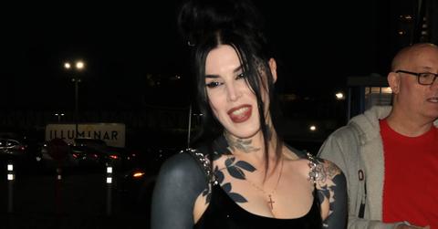 Kat Von D in a sleeveless dress with blacked out tattoos on her arms