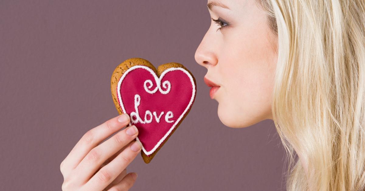 Woman posing with a heart-designed cookie