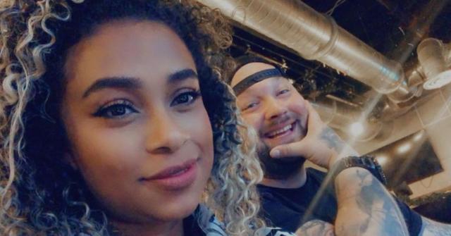 Jojo Offerman with Bray Wyatt posing behind her.