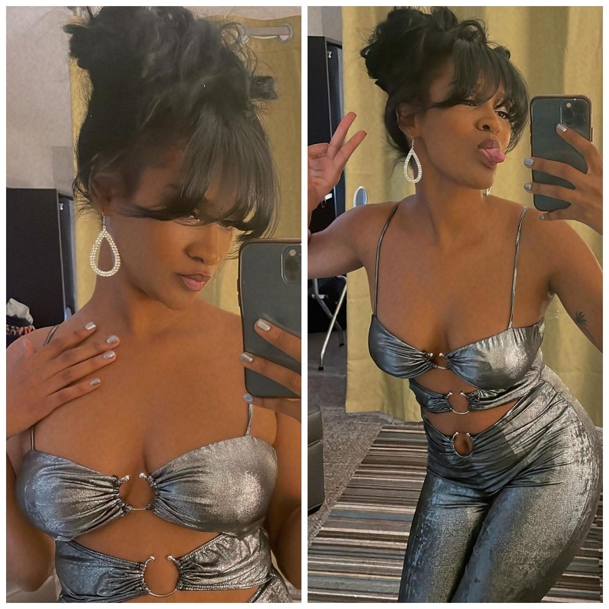 Woman wears aluminum/silver jumpsuit and poses in the mirror.