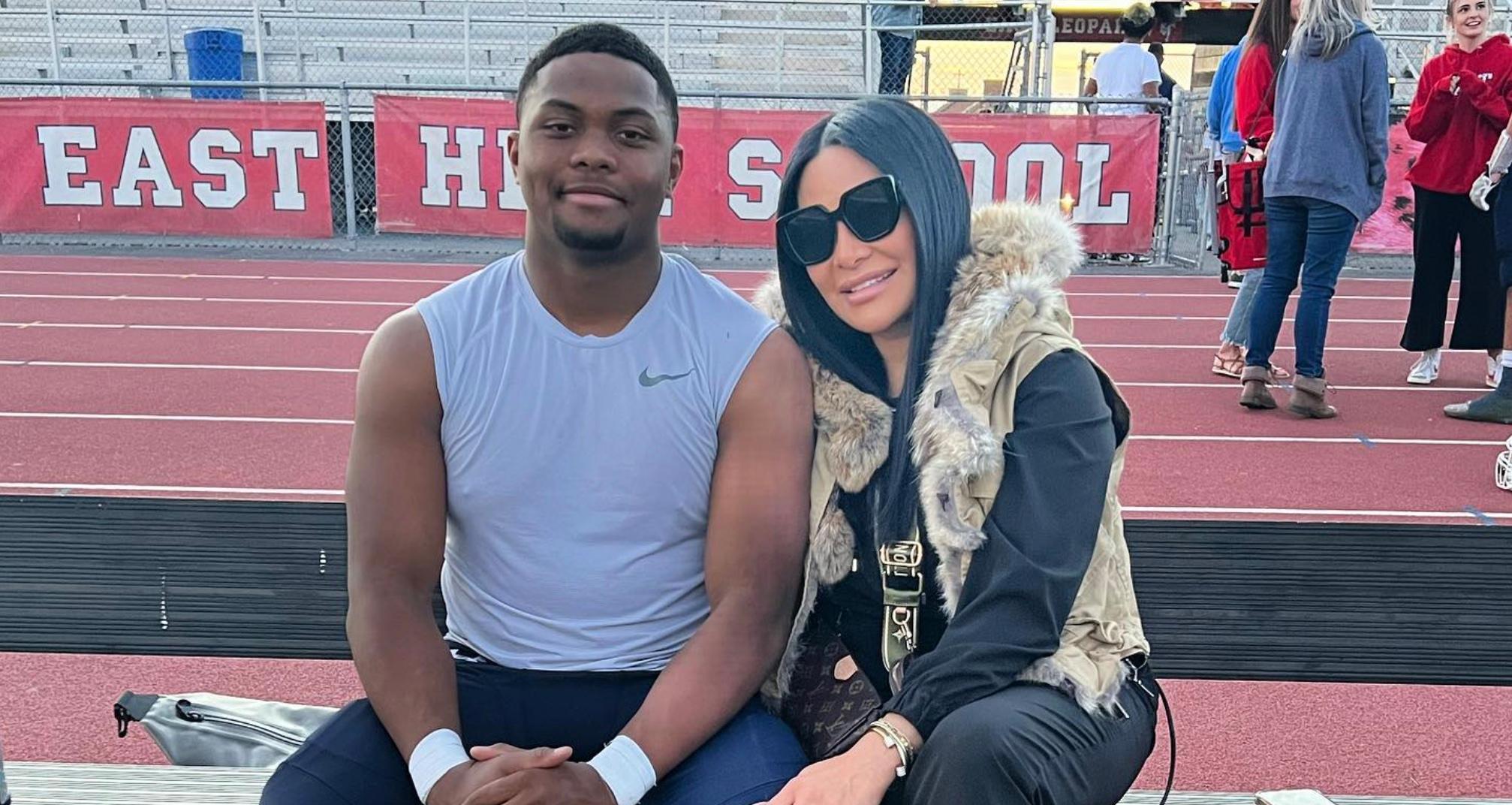 Jen Shah and her son Omar sitting on a bench at a high school track