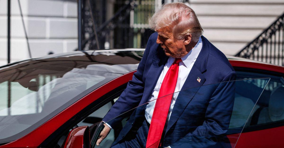 Donald Trump getting into a Tesla. 