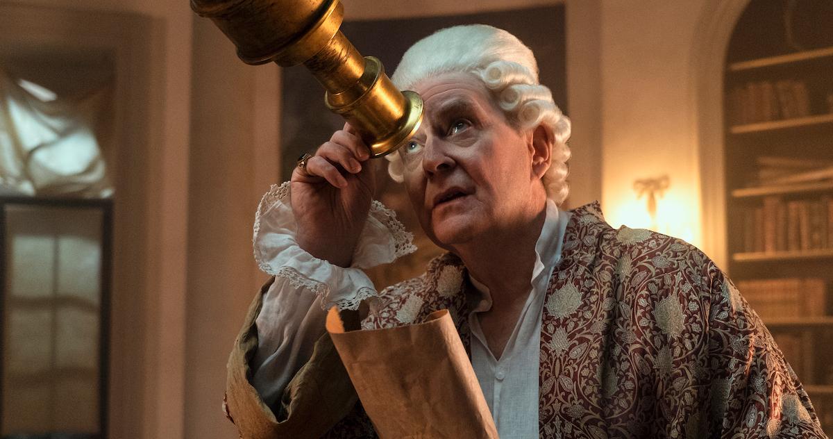 King George III looking through a telescope on 'Queen Charlotte: A Bridgerton Story'