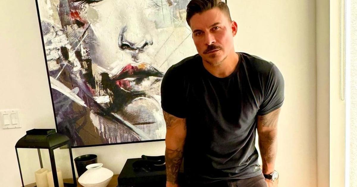 Jax Taylor leans against a table in his home