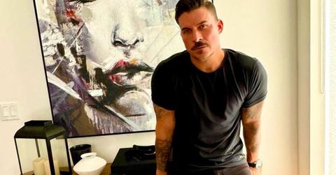 Jax Taylor leans against a table in his home