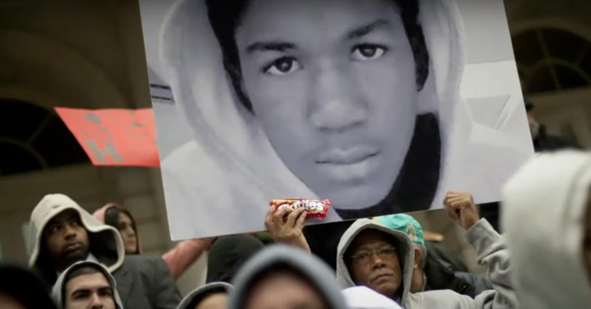 A photo of Trayvon Martin with a bag of Skittles is held up at a protest