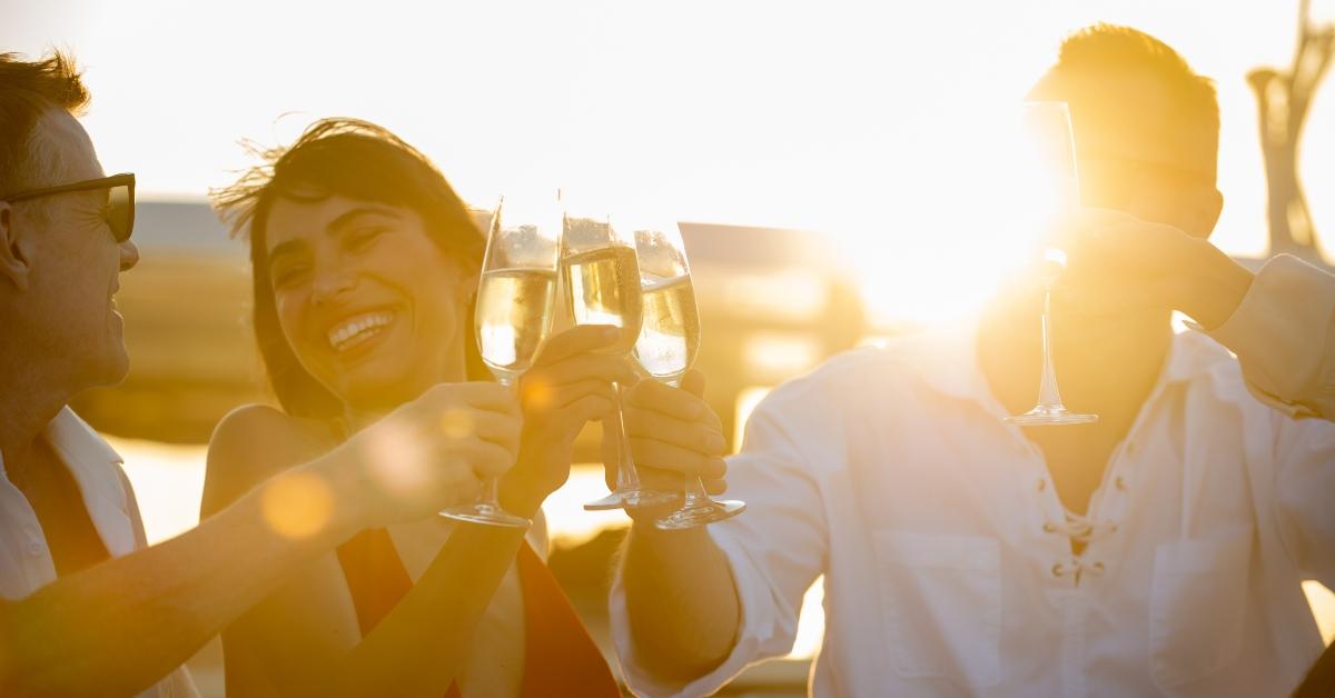 friends enjoy drinking champagne while catamaran boat sailing on summer vacation