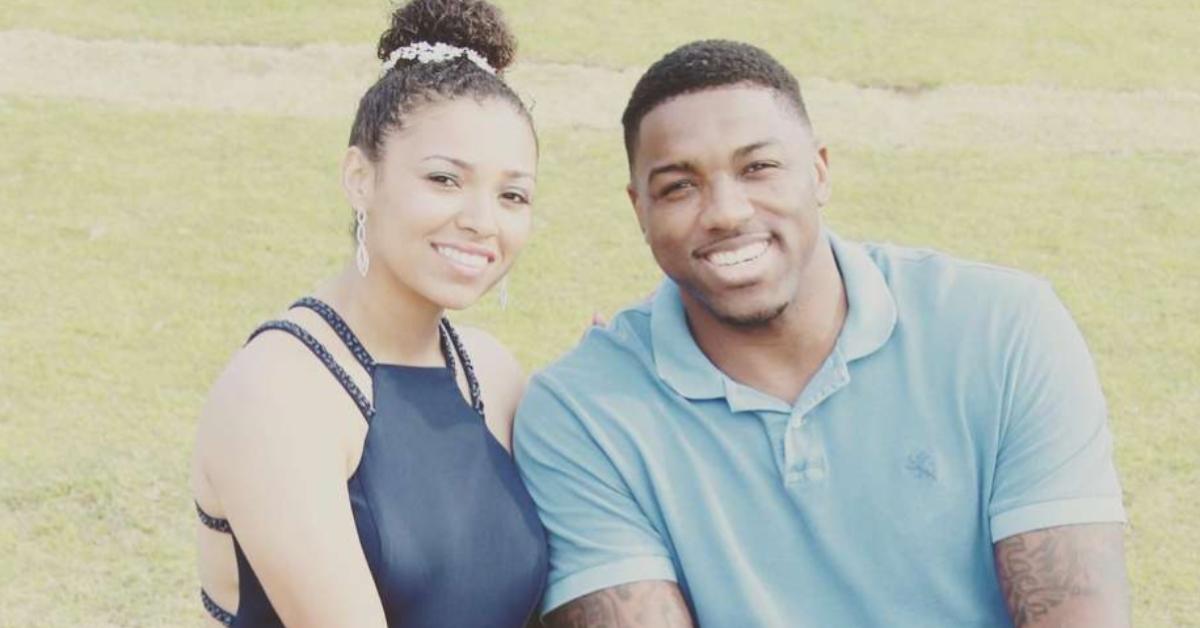 Aniah Blanchard and Walt Harris sit by a field, smiling