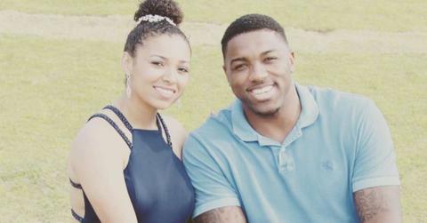 Aniah Blanchard and Walt Harris sit by a field, smiling