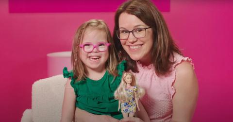 mom and daughter with down syndrome play with barbie doll with down syndrome