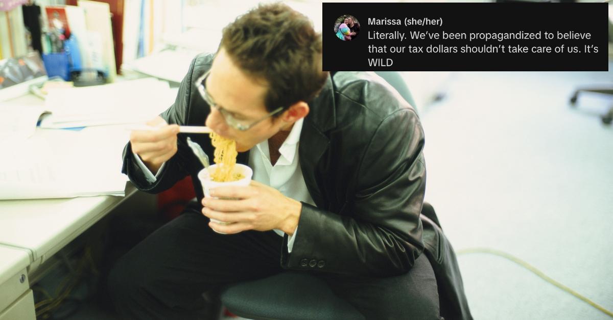 Guy eats ramen noodles at his desk.