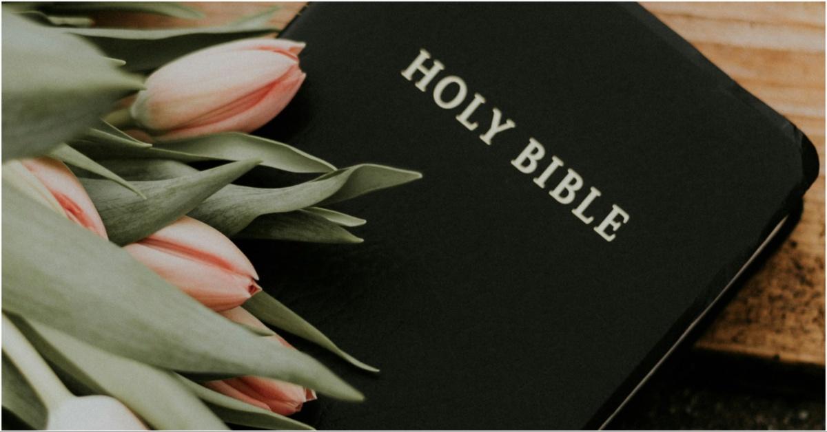 A photo of a bible with flowers on top of it