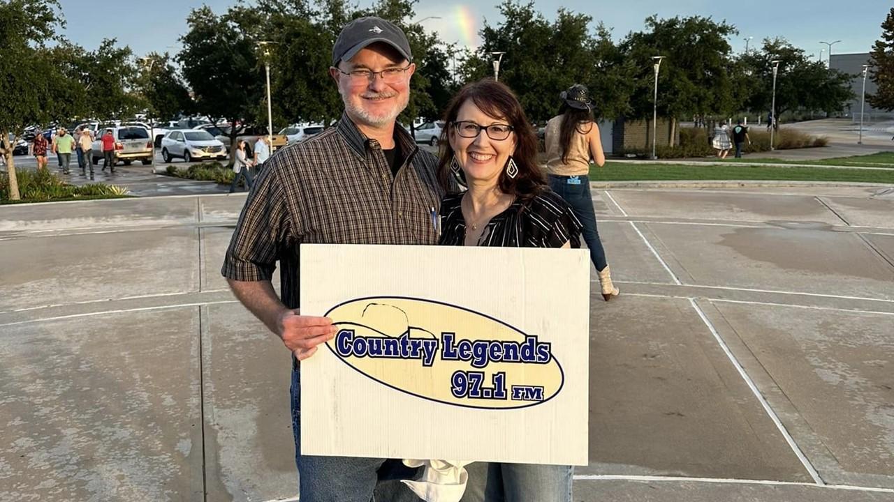 Fans holding a 97.1 Country Legends sign