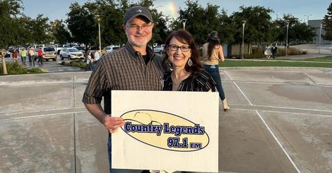 Fans holding a 97.1 Country Legends sign