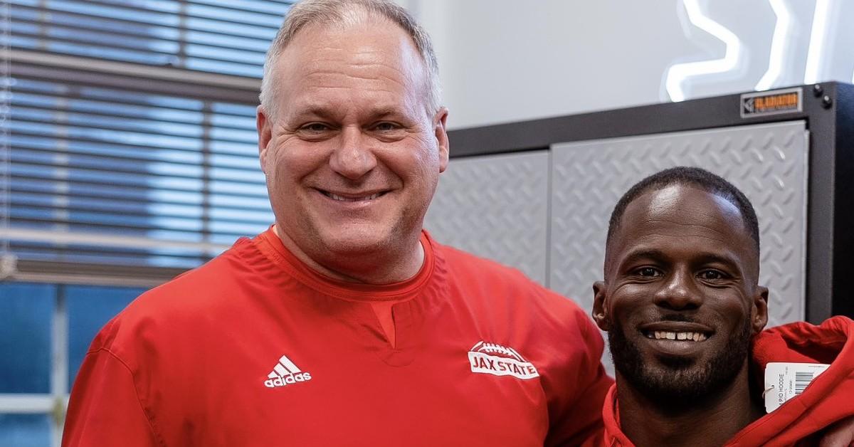 Rich Rodriguez standing with one of his players