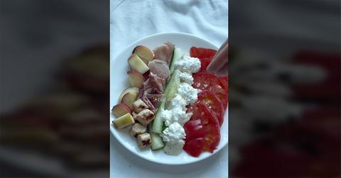 A "girl dinner" that features cheese, tomato, and some vegetables.