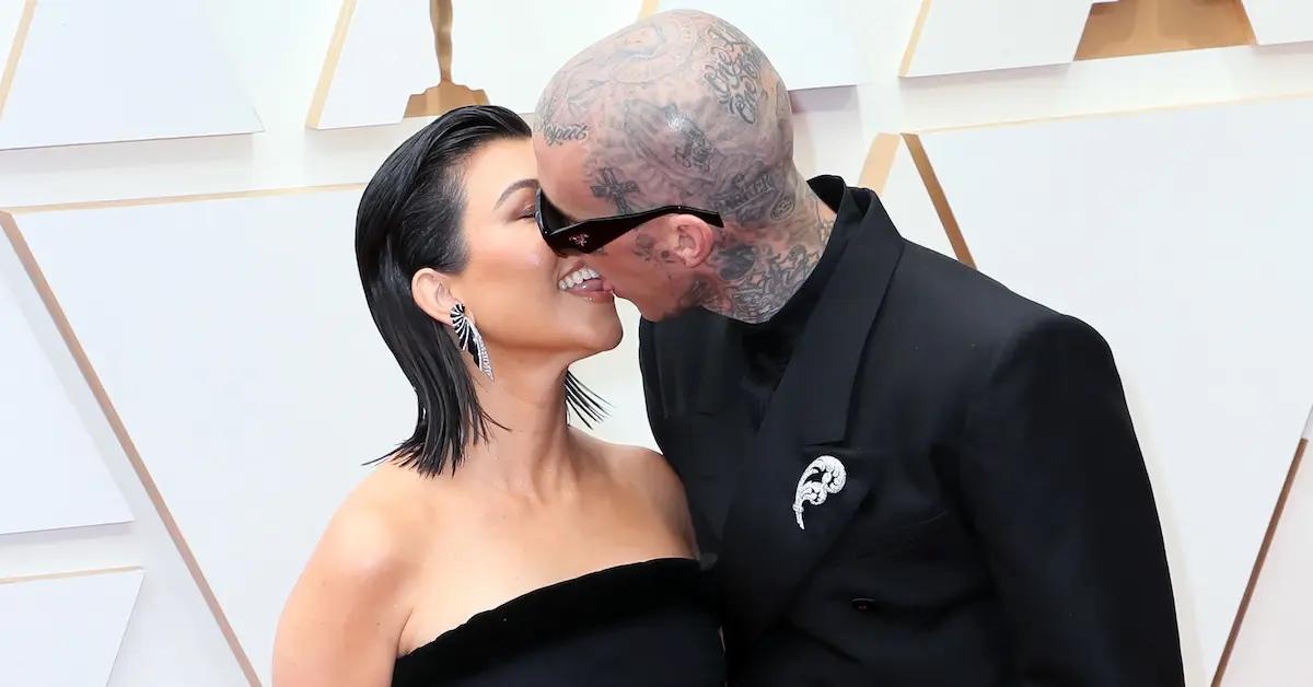 Kourtney Kardashian and Travis Barker kiss at event.