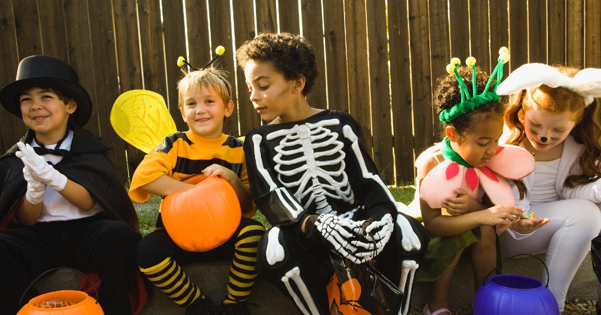 Kids in Halloween costumes looking at their candy.