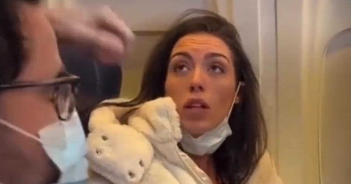 A woman breastfeeding a cat on a plane