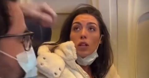 A woman breastfeeding a cat on a plane