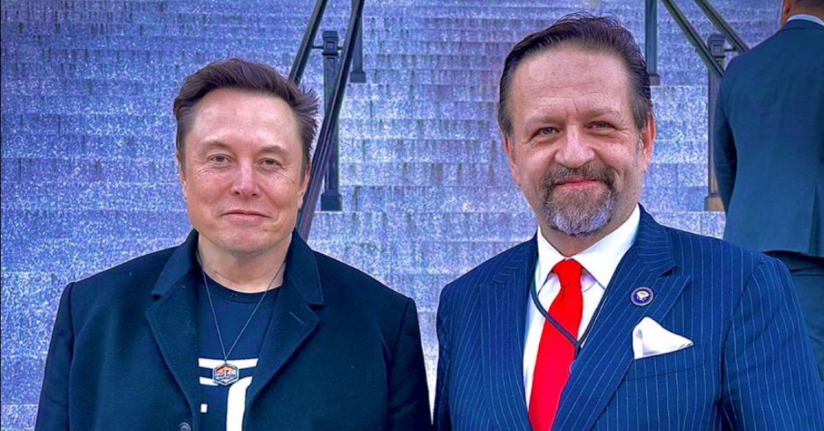 Elon Musk with a Trump official wearing a necklace around his neck. 